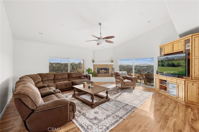 living room with light wood-type flooring, high vaulted ceiling, and ceiling fan