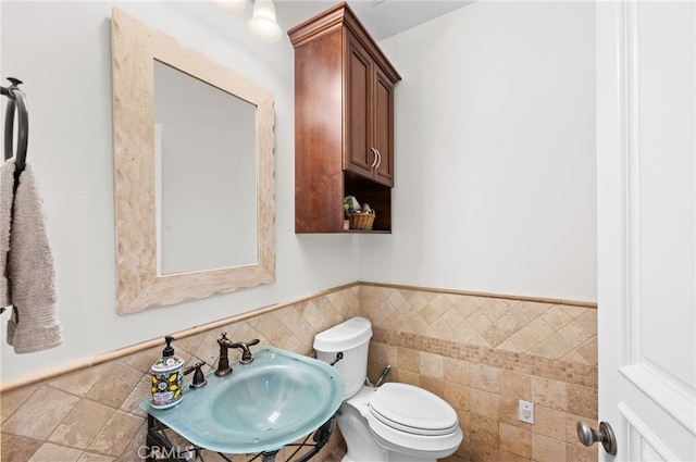 2240 Aqua Hill Rd, Fallbrook, CA 92028 - bathroom featuring toilet, tile walls, a wainscoted wall, and a sink
