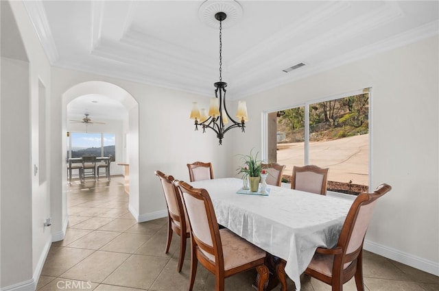 dining space with a wealth of natural light, light tile patterned floors, ornamental molding, and a raised ceiling