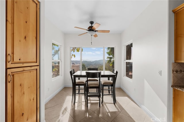 dining area with ceiling fan, a wealth of natural light, and a mountain view