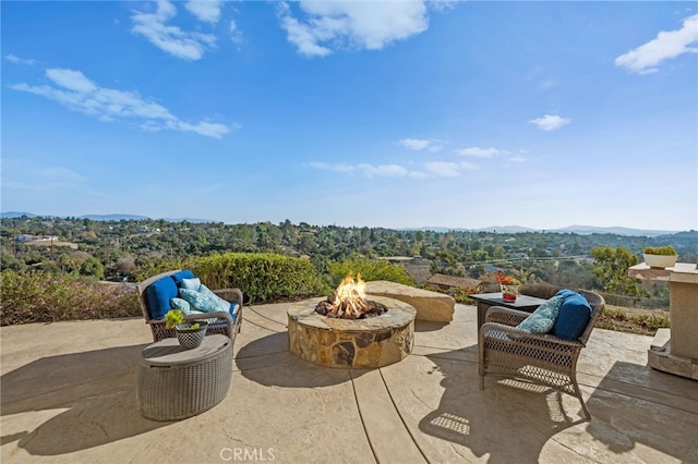 view of patio / terrace with an outdoor fire pit and a mountain view