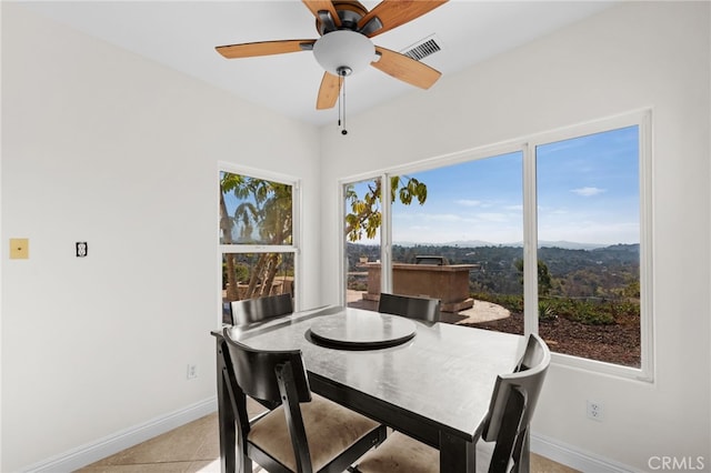 tiled dining space featuring a healthy amount of sunlight and ceiling fan