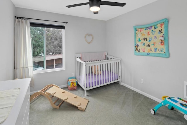 bedroom with ceiling fan, a nursery area, and carpet flooring