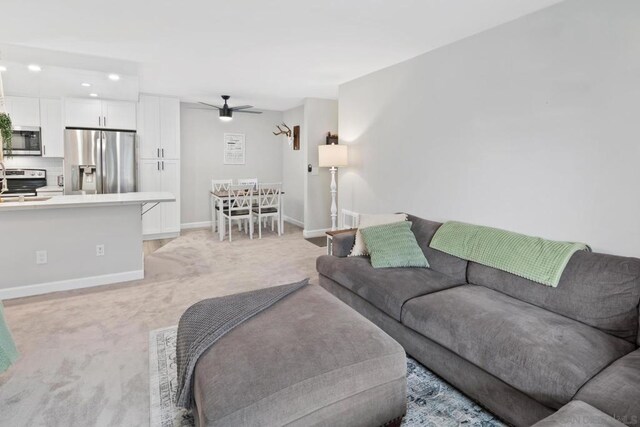 living room featuring ceiling fan and light colored carpet