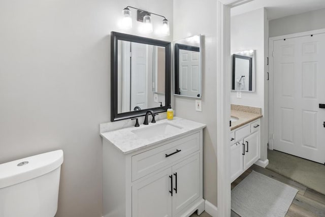 bathroom with toilet, wood-type flooring, and vanity