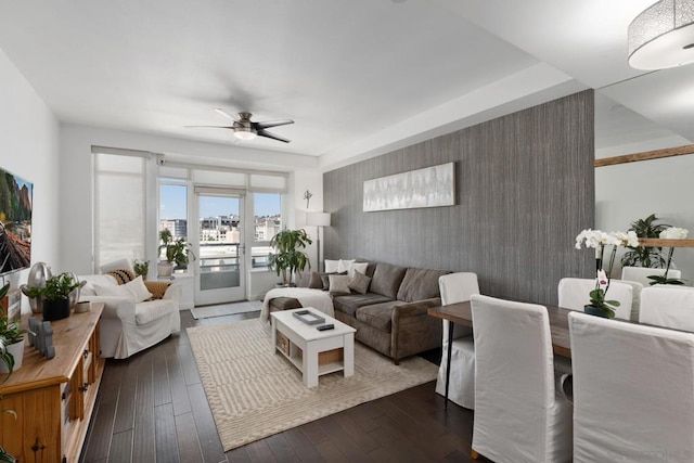 living room featuring ceiling fan and dark wood-type flooring