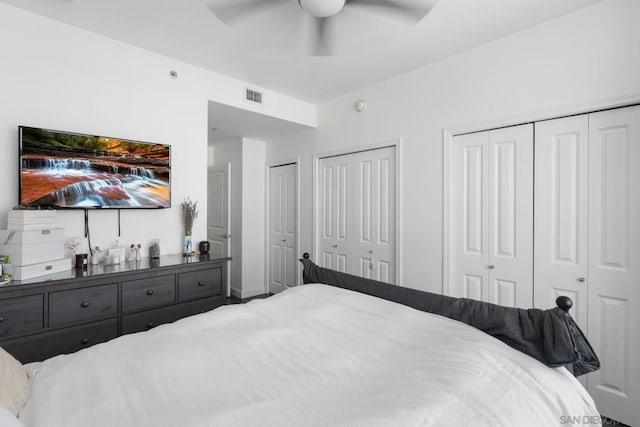 bedroom featuring ceiling fan and multiple closets