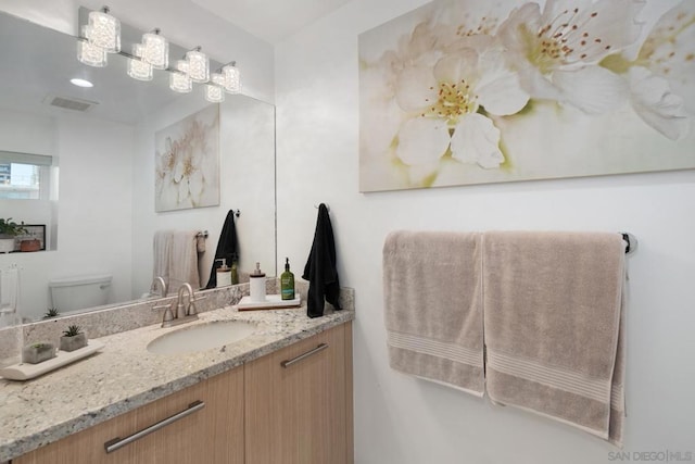 bathroom featuring toilet and vanity