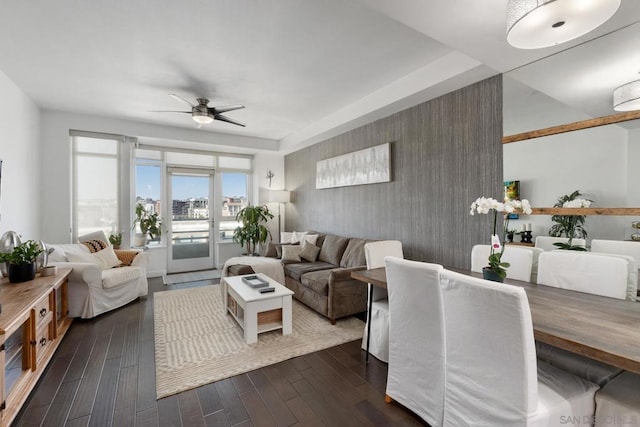 living room featuring dark wood-type flooring and ceiling fan