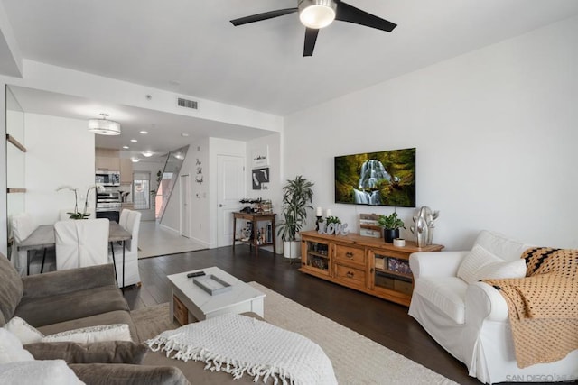 living room featuring ceiling fan and dark hardwood / wood-style floors