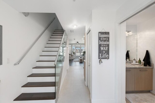 stairs featuring ceiling fan