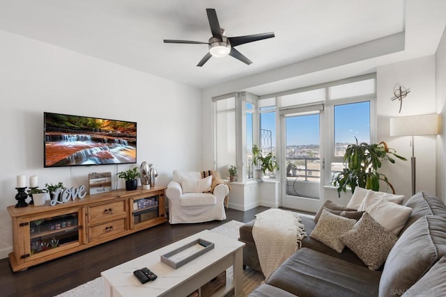 living room featuring dark wood-type flooring and ceiling fan