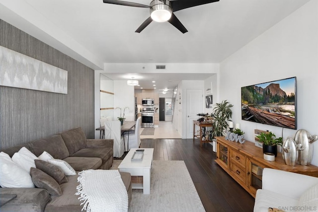 living room with ceiling fan and dark hardwood / wood-style flooring