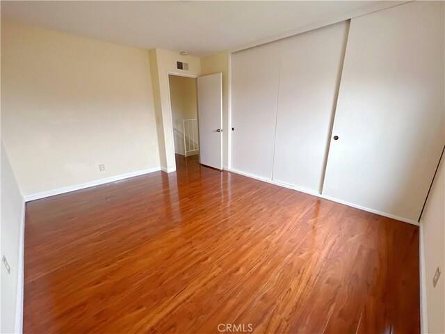 unfurnished bedroom featuring hardwood / wood-style floors and a closet