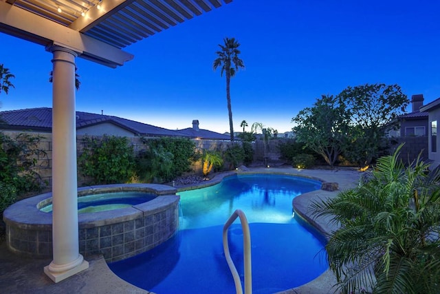 pool at dusk featuring an in ground hot tub