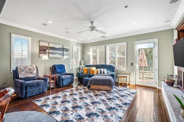 living area with dark hardwood / wood-style flooring, a wealth of natural light, and crown molding