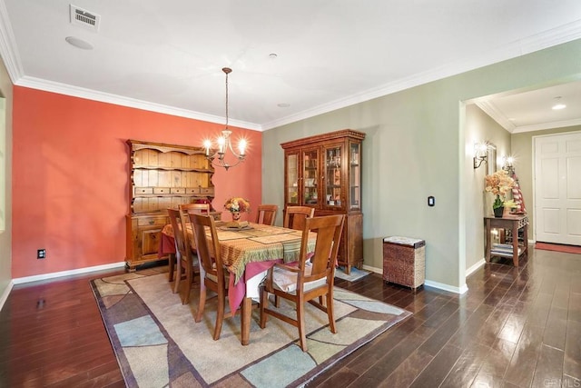 dining space featuring dark hardwood / wood-style floors, ornamental molding, and an inviting chandelier