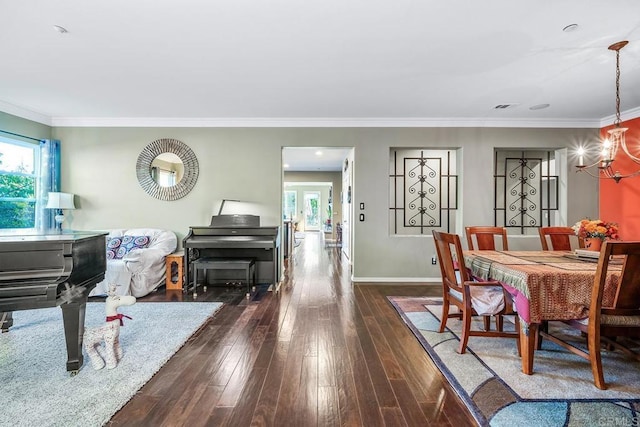 dining area with crown molding, dark hardwood / wood-style floors, and a notable chandelier