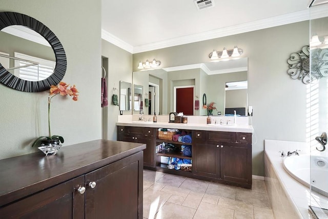 bathroom with tiled tub, vanity, crown molding, and tile patterned flooring