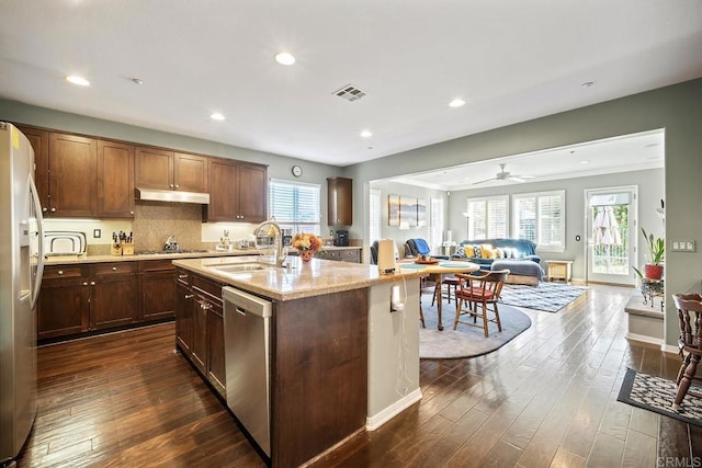 kitchen with a kitchen island with sink, dark hardwood / wood-style floors, sink, and stainless steel appliances