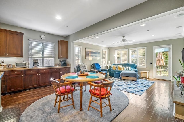 dining room with ceiling fan, dark hardwood / wood-style flooring, and crown molding