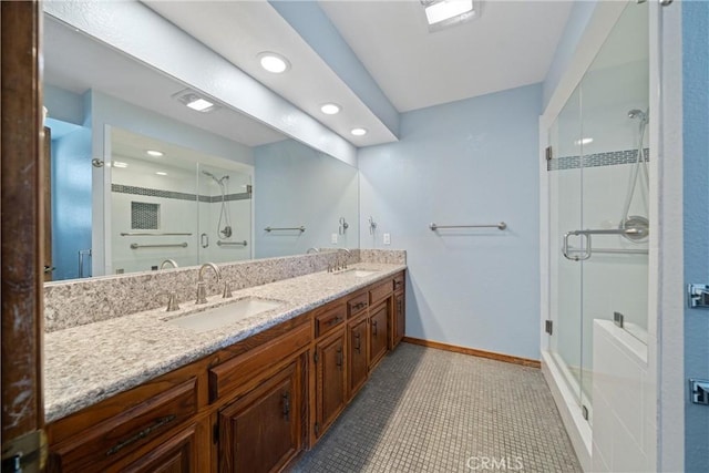 bathroom featuring tile patterned flooring, a shower with shower door, and vanity