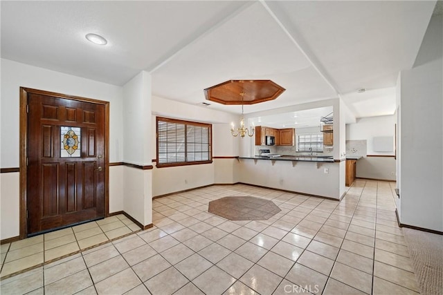 foyer entrance featuring light tile patterned floors and a notable chandelier