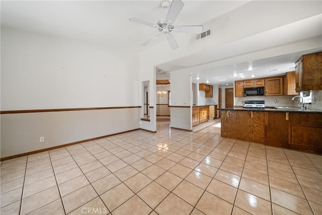 kitchen featuring range, sink, kitchen peninsula, ceiling fan, and light tile patterned floors