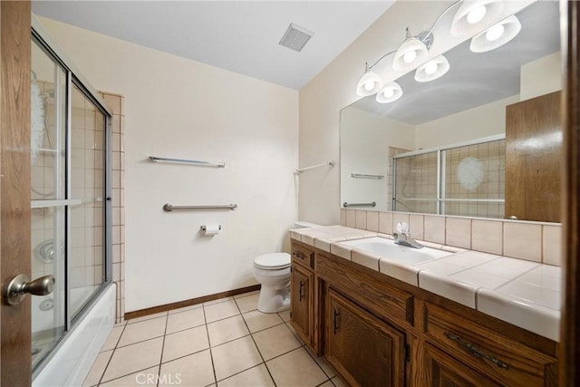 full bathroom featuring toilet, tile patterned flooring, vanity, and shower / bath combination with glass door