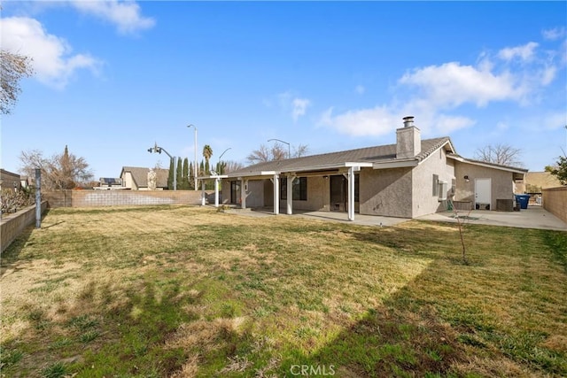 rear view of property with a yard and a patio