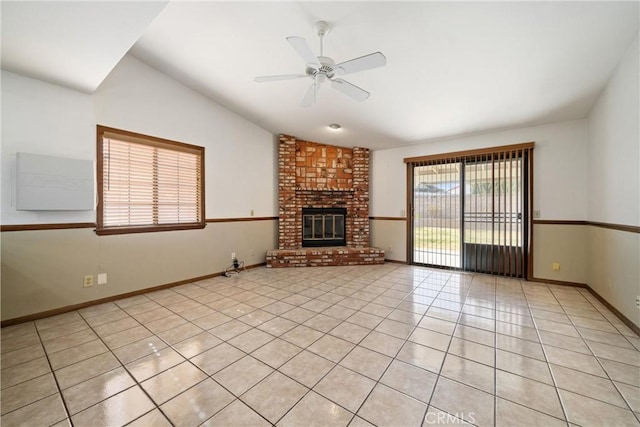 unfurnished living room with a brick fireplace, light tile patterned floors, lofted ceiling, and ceiling fan