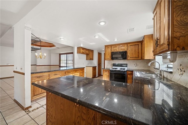 kitchen featuring an inviting chandelier, light tile patterned floors, kitchen peninsula, stove, and sink