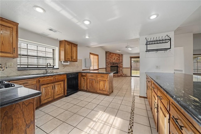 kitchen with ceiling fan, dishwasher, kitchen peninsula, sink, and light tile patterned floors