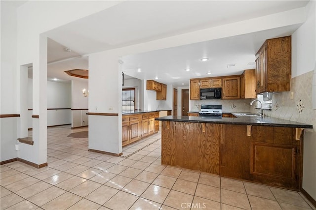 kitchen with sink, backsplash, kitchen peninsula, gas range, and light tile patterned floors