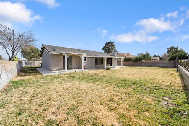 back of property featuring a lawn and a patio