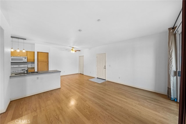 unfurnished living room with ceiling fan and light hardwood / wood-style floors