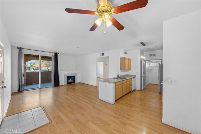 kitchen featuring light hardwood / wood-style floors, sink, ceiling fan, stainless steel refrigerator, and white dishwasher