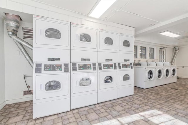 washroom with stacked washing maching and dryer and separate washer and dryer