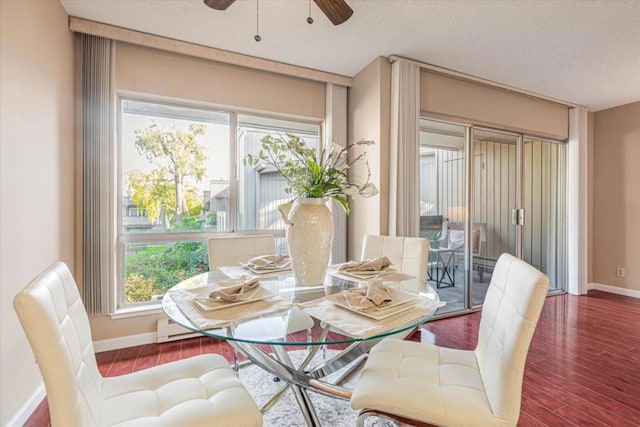 dining space with ceiling fan and dark wood-type flooring