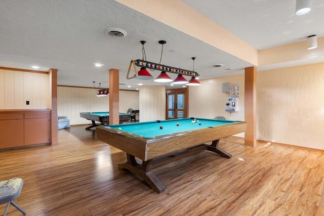 rec room featuring light wood-type flooring, wood walls, french doors, and billiards