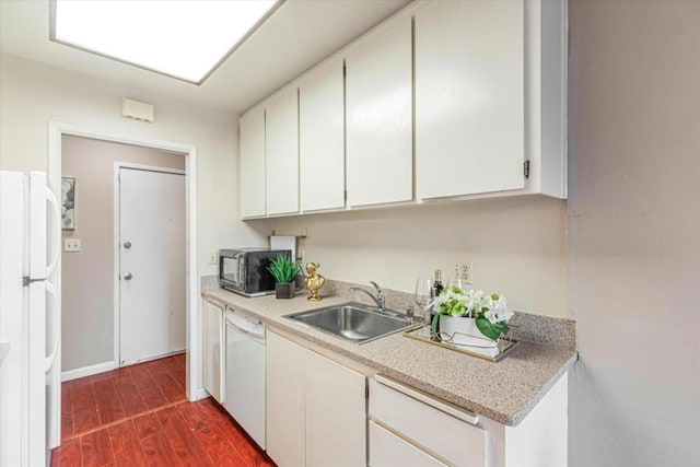 kitchen featuring white cabinetry, sink, and white appliances