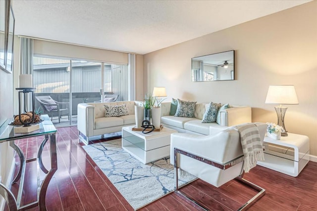 living room with ceiling fan and dark wood-type flooring