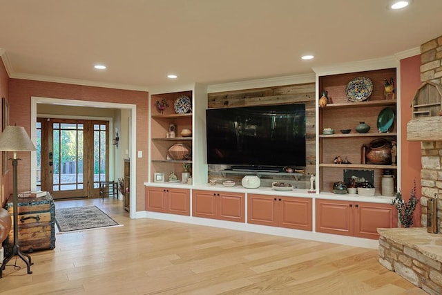 living room with crown molding, light hardwood / wood-style floors, and built in features