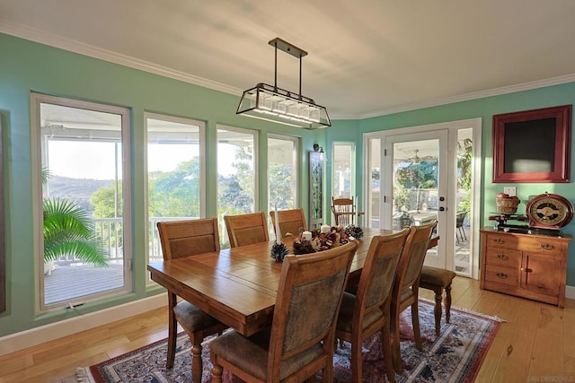 dining space with ornamental molding and light hardwood / wood-style floors