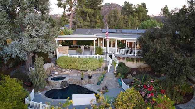 rear view of property with a patio area, exterior bar, and solar panels