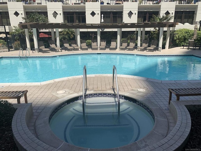 view of swimming pool with a hot tub and a patio