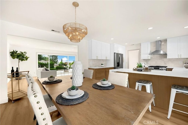 dining area with light hardwood / wood-style flooring and a chandelier