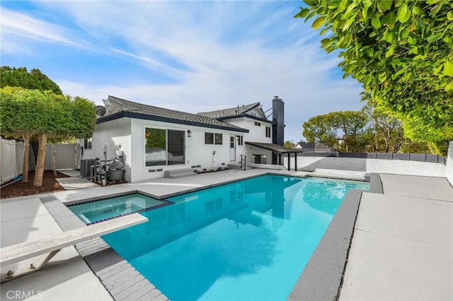 back of house with a pool with hot tub, a patio area, and central AC