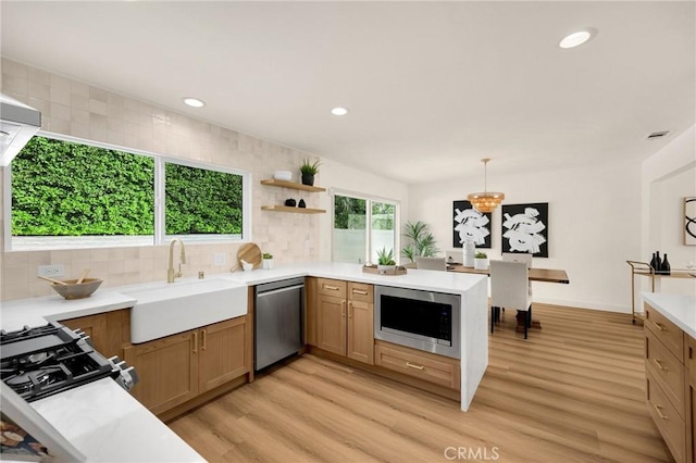 kitchen with stainless steel appliances, tasteful backsplash, hanging light fixtures, and sink