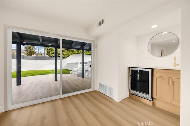 doorway featuring light hardwood / wood-style floors, sink, and wine cooler